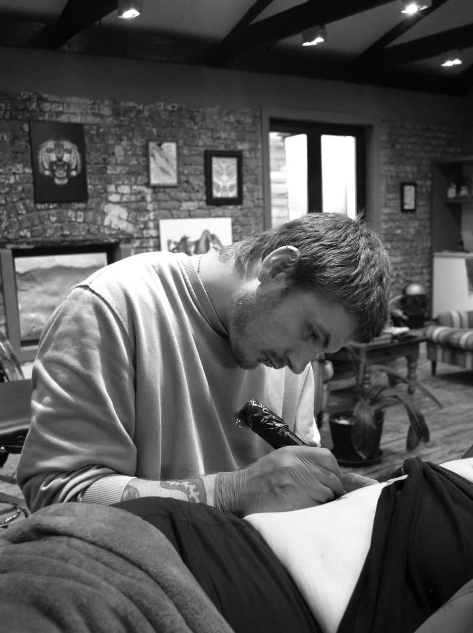 Kyle Henry, founder of FlyTrap Tattoos, tattooing a client in the studio