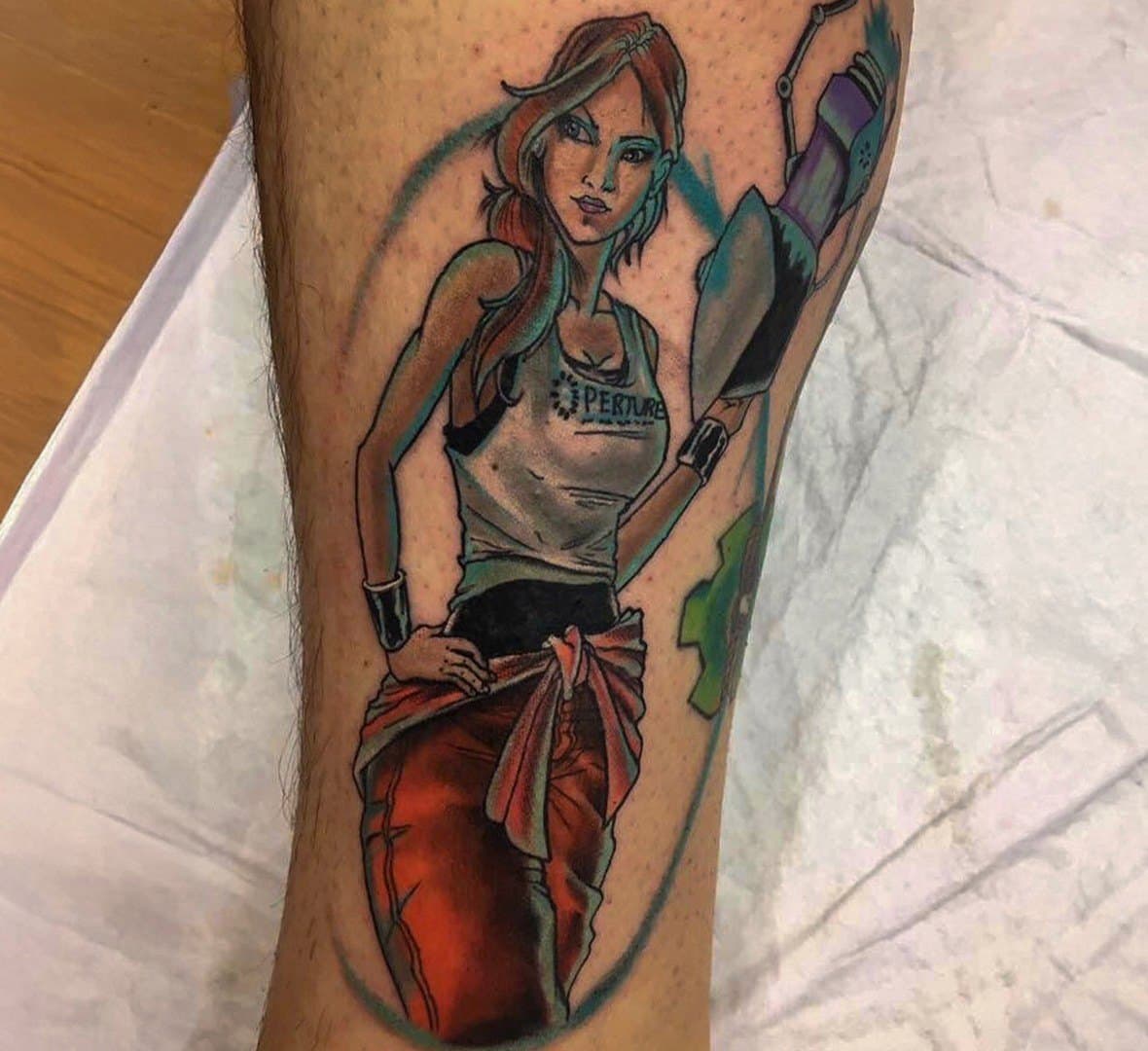 Colour tattoo of a woman in a vest and red wrap on a calf